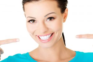 woman smiling and pointing to white smile