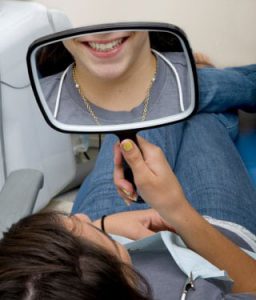 dental patient looking at smile in mirror